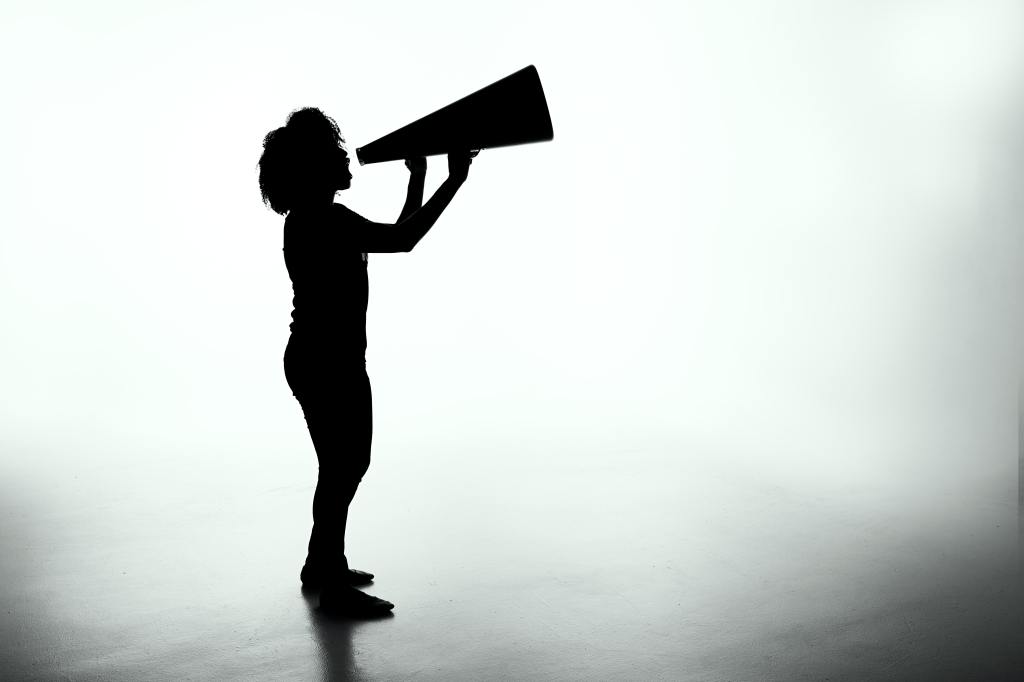 A person in profile holding a megaphone