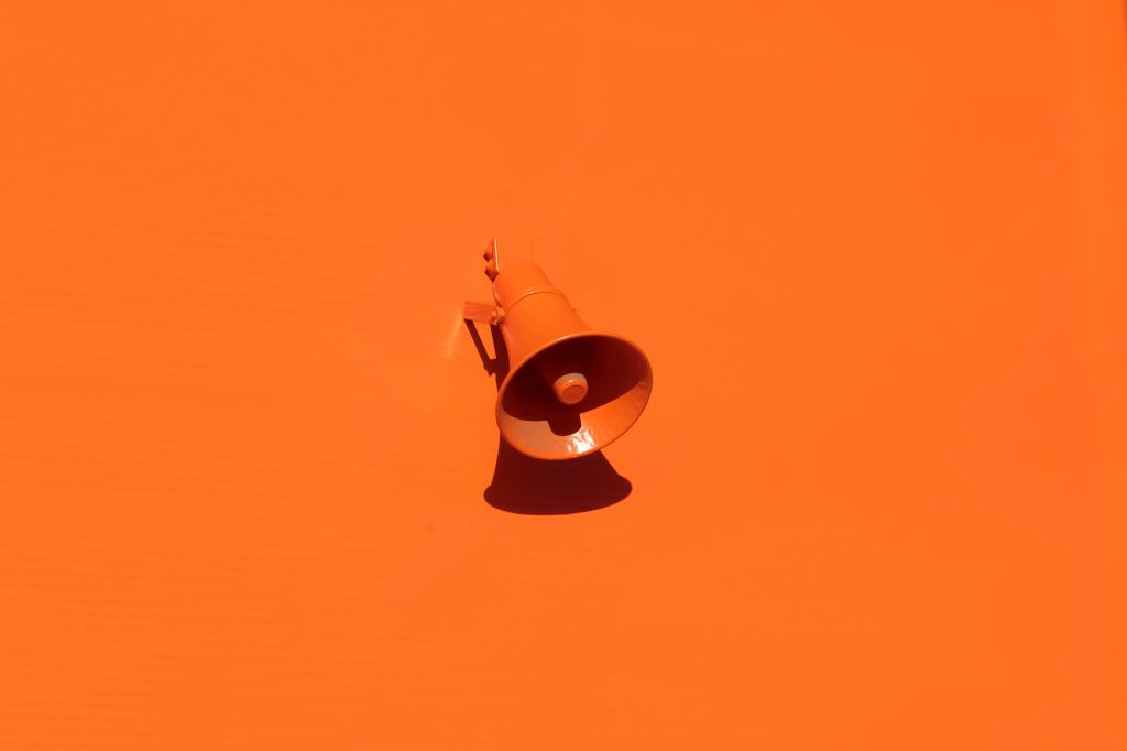 An Orange megaphone on an orange background